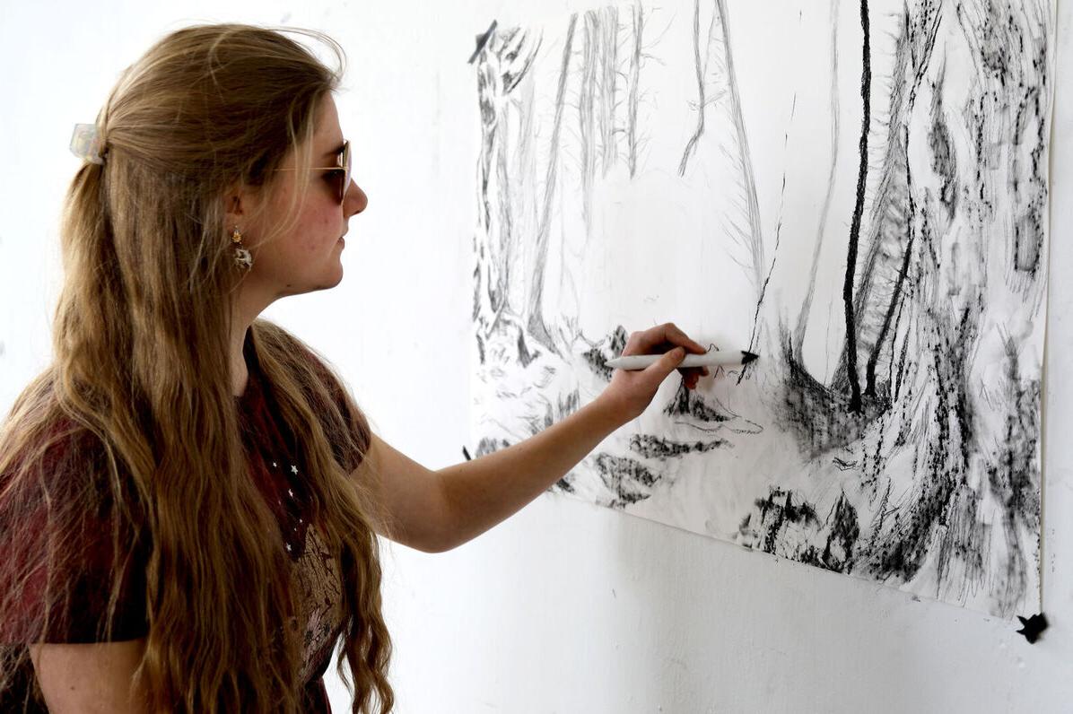 一位女性艺术俱乐部成员在艺术俱乐部会议期间在墙上创作艺术